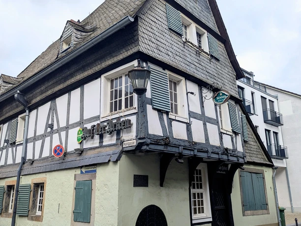 ©Bastian Ulrich - Haus auf der Arken 2 Das Foto zeigt ein markantes Fachwerkhaus mit grauem Schieferdach.