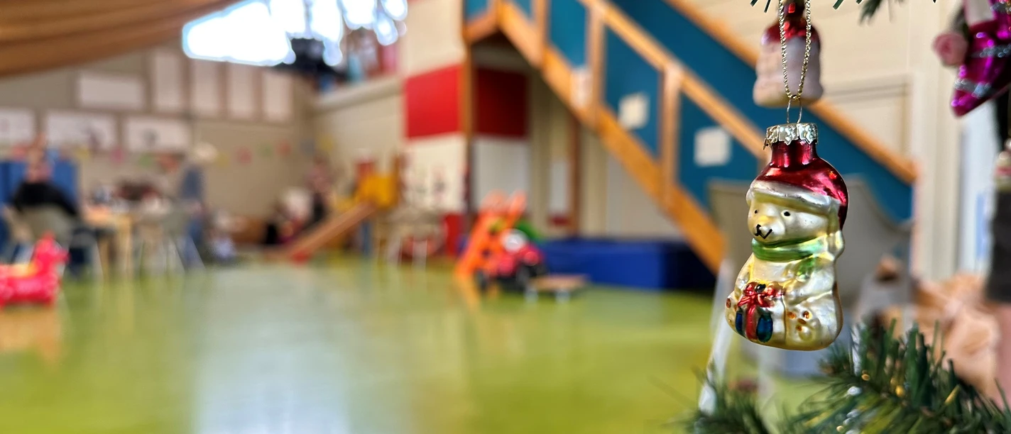 Kinderspielhaus_22-12_Weihnachten8_Wesler.jpg Weihnachtlich geschmückter Raum im Kinderspielhaus mit glänzendem Baumschmuck und Spielgeräten