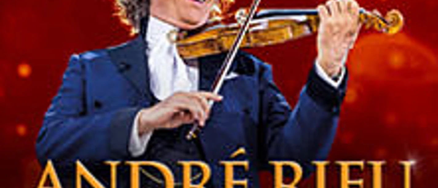André Rieu spielt Geige vor rotem Hintergrund mit Orchester.