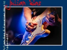 Gitarrist spielt auf Elektrogitarre bei einem Konzert, blauer Hintergrund, Albumcover.