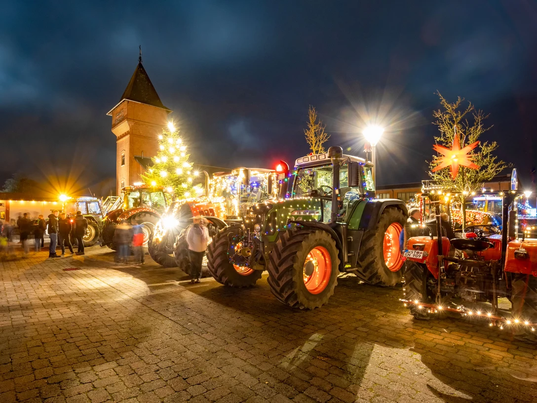 Lichterfahrt.jpg Festlich beleuchtete Traktoren und ein Weihnachtsbaum vor einem historischen Turm bei Nacht.Festively illuminated tractors and a Christmas tree in front of a historic tower at night.Festligt oplyste traktorer og et juletræ foran et historisk tårn om natten.Feestelijk verlichte tractoren en een kerstboom voor een historische toren bij nacht.