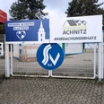 Walter-Mundorf-Stadion Eingang mit Werbetafeln und Siegburg-Logo in blau-weißer Farbgebung.