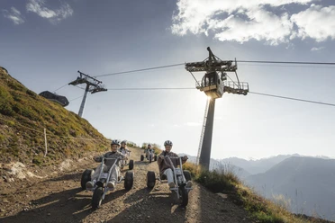 Mountaincart unter der Gletscherbahn Moosfluh Junge Fahrer erleben das Mountaincart Aletsch Arena bei einer rasanten Abfahrt unter der Gondelbahn der Riederalp