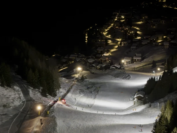 Illuminated descent above the Riederalp at night When skiing at night in Bettmeralp Riederalp, the ski slopes above the village light up brightly and form a fascinating contrast to the dark mountain landscape