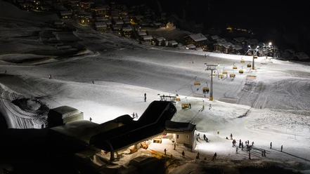 Panoramablick auf die Pisten beim Nachtskifahren in der Aletsch Arena Das Nachtskifahren Bettmeralp Riederalp zeigt beleuchtete Pisten, Sessellifte und Skifahrer im Winterparadies der Aletsch Arena unter klarem Sternenhimmel
