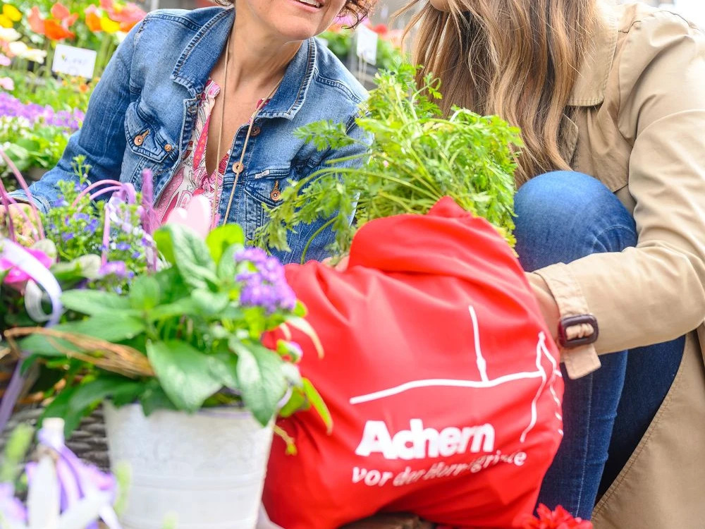 Zwei Frauen umrahmt von Blumen und Pflanzen auf Mille Fleurs