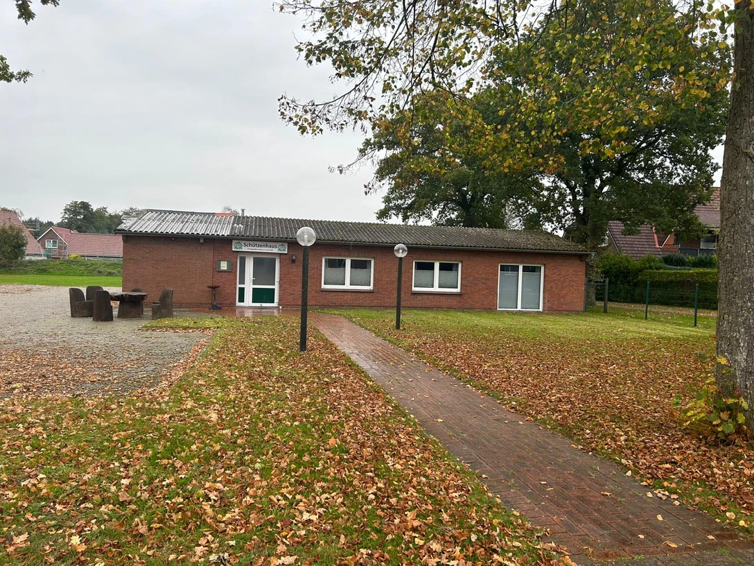 Schützenhaus Augustfehn-Bokel.jpeg Backsteingebäude mit Flachdach, umgeben von herbstlichem Laub und Bäumen im Ort Augustfehn-Bokel.