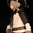 Räuber Ratte (C) Puppentheater Pulcinella Handpuppe einer grauen Ratte mit schwarzem Hut, Umhang und Augenmaske vor dunklem Hintergrund.