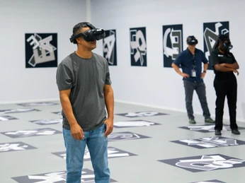 VR-Experience - Titanic: Eine Immersive Reise Drei Personen stehen mit VR-Brillen in einem großen Raum und beobachten eine VR-Experience bei der Ausstellung "Titanic: Eine Immersive Reise"Three people wearing VR goggles stand in a large room and observe a VR experience at the exhibition "Titanic: An Immersive Voyage"Tři lidé s brýlemi VR stojí ve velké místnosti a sledují zážitek VR na výstavě "Titanic: An Immersive Voyage".Trzy osoby noszące gogle VR stoją w dużym pomieszczeniu i oglądają doświadczenie VR na wystawie "Titanic: An Immersive Voyage".Drie mensen met een VR-bril staan in een grote ruimte en bekijken een VR-ervaring op de tentoonstelling "Titanic: An Immersive Voyage".Tre persone che indossano occhiali VR si trovano in una grande stanza e guardano un'esperienza VR alla mostra "Titanic: An Immersive Voyage".