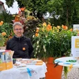 Reiner Dunker, Energieexperte Verbraucherzentrale Niedersachsen.jpg Ein Mann mit Infostand zur Energieberatung vor blühenden Pflanzen im Freien.
