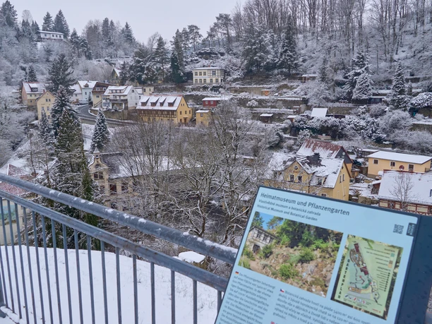 Winter view of a snow-covered village with information map in the foreground.