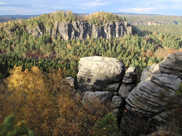 Rock formations and forest in the fall with a view of a valley.