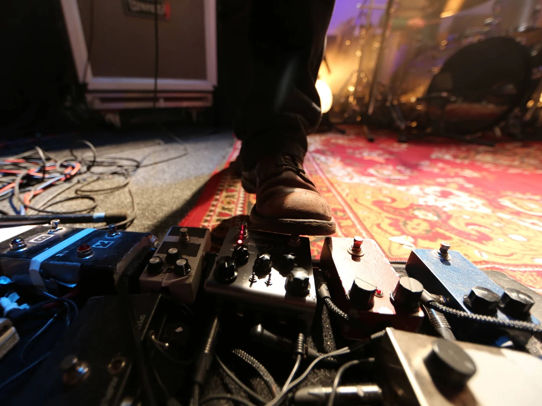 c/o pop Festival Cologne Ein Fuß betätigt Effektgeräte auf einer Bühne, umgeben von Kabeln und einem Teppich.A foot operates effect devices on a stage, surrounded by cables and a carpet.