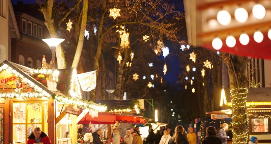 Weihnachtsmarkt in der Innenstadt Weihnachtsmarktstände in der festlich beleuchteten Innenstadt mit einigen Besuchern.