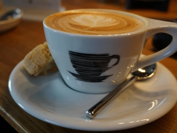 pottschwarz, Mülheim an der Ruhr Kaffeetasse mit Crema im Café Pottschwarz, daneben ein Stück Gebäck und ein Löffel