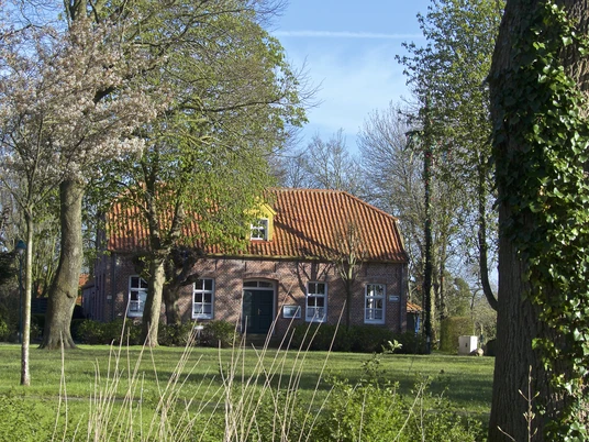Jugend- und Kulturhaus Visquard Blick auf das Jugend- und Kulturhaus, Bäume, Wiese, blauer Himmel