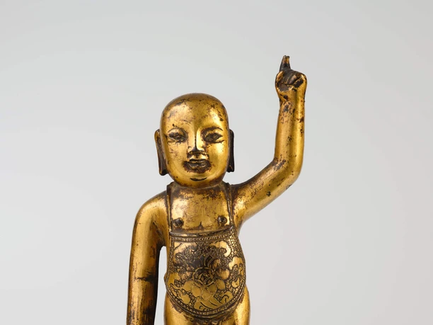 The newborn Buddha Golden Buddha statue standing on a lotus blossom, raising one arm.