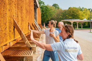 Gruppe bei Atemübungen am Gradierwerk im Kurpark Bad Salzuflen