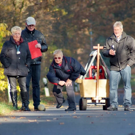 Boßeln im Emsland 03 ©Ute Müller (nordmedia).JPG Gruppe von Menschen boßelt fröhlich auf einer Landstraße im herbstlichen Emsland.