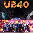 Die Band UB40 steht vor einer bunt bemalten Wand unter einem dunklen Brückenbogen.
