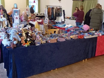 Adventsbasar im Schützenhof.jpg Verkaufsstand mit handgefertigten Strickwaren, Wollmützen und gehäkelten Stofftieren in Halle.