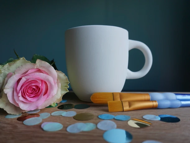 Pinselei.JPG Weißer Becher und Pinsel