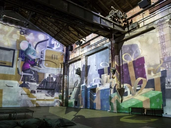 9 - Kunstkraftwerk Leipzig - Traumfabrik-c-Andreas-Schmidt.jpg Industrielle Halle mit projizierten Geschenk-Motiven und einer Cartoon-Maus.Industrial hall with projected gift motifs and a cartoon mouse.Průmyslová hala s promítanými dárkovými motivy a kreslenou myší.Industrialna hala z wyświetlanymi motywami prezentów i kreskówkową myszą.Industriële hal met geprojecteerde geschenkmotieven en een cartoonmuis.Capannone industriale con motivi regalo proiettati e un topo dei cartoni animati.
