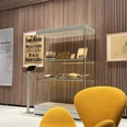 View of the exhibition "Paving the way for change" Eine Ausstellungsvitrine mit beleuchteten historischen Dokumenten und Bildern in einem modernen Raum.An exhibition showcase with illuminated historical documents and pictures in a modern room.