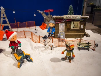 12 - Sandmännchen in Leipzig - Foto Andreas Schmidt.jpg Figurenlandschaft mit Sandmännchen-Themen, Winterkulisse, Schneemännern und Mini-Liftstation.Figure landscape with Sandman themes, winter scenery, snowmen and mini lift station.Obrázek krajiny s motivy Písečného muže, zimní scenérie, sněhuláci a stanice mini výtahu.Figurkowy krajobraz z motywami Sandmana, zimowa sceneria, bałwany i mini stacja kolejki linowej.Figuurlandschap met Sandman-thema's, winterlandschap, sneeuwpoppen en miniliftstation.Paesaggio di figure con temi di Sandman, scenari invernali, pupazzi di neve e mini-stazione di risalita.