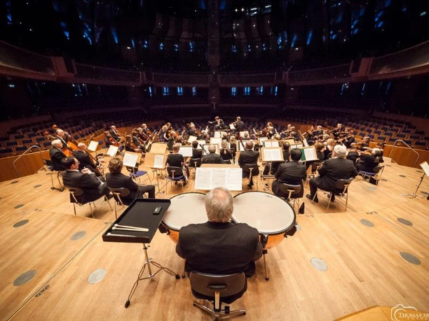 Oster Matinee 2026 Orchester Ein großes Orchester probt in einem modernen Konzertsaal mit klarer Akustik.