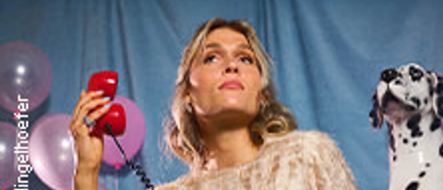 Eine Frau mit Telefon, rosa Luftballons im Hintergrund, Dalmatiner daneben.