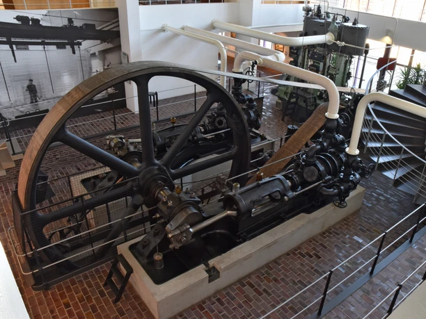 Historisches Museum HMB_Kältemaschine (c) Jutta Drabek-Hasselmann_Erlebnis Bremerhaven.jpg Historische Kältemaschine mit Schwungrad und Rohrleitungen im Industrieraum des Museums.
