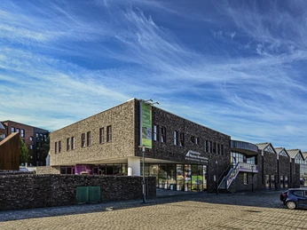 Historisches Museum HMB_HMB aussen 2022 (c) Historisches Museum Bremerhaven.jpg Backsteingebäude des Historischen Museums Bremerhaven unter blauem Himmel mit Glasfassade.