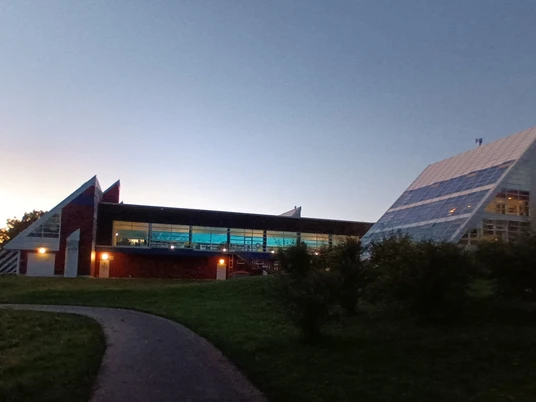 Thermalsolbad_Abendstimmung (5)_HD.jpg Thermalsolbad mit beleuchtetem Innenbecken vor blauem Abendhimmel und grüner Wiese.Thermal saltwater pool with illuminated indoor pool against a blue evening sky and green meadow.Termisk saltvandsbassin med oplyst indendørs bassin mod en blå aftenhimmel og en grøn eng.Thermaal pekelbad met verlicht binnenbad tegen een blauwe avondlucht en groene weide.