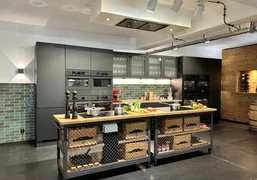 IMG_8822.jpg Moderne Küche mit dunklen Schränken, Holzarbeitsplatte und beleuchteten grünen Fliesen.Modern kitchen with dark cabinets, wooden worktop and illuminated green tiles.