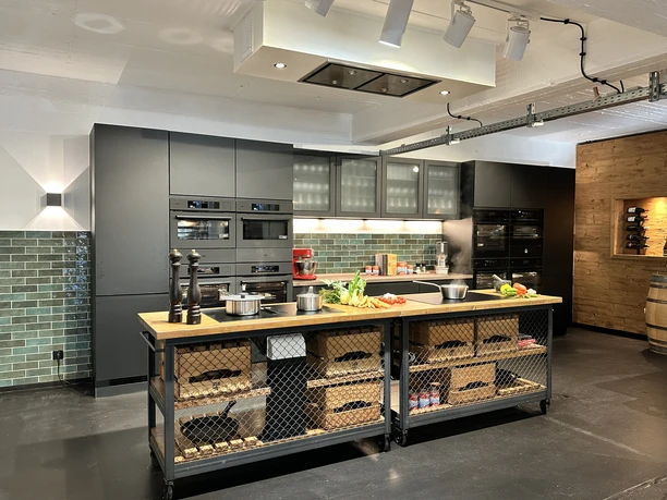 IMG_8822.jpg Modern kitchen with dark cabinets, wooden worktop and illuminated green tiles.