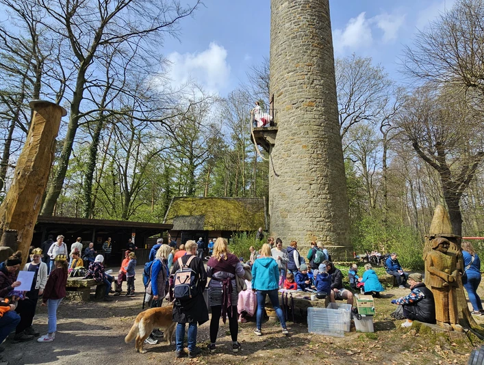 Rapunzel-Turm-Tag Kinder und Erwachsene versammeln sich vor einem steinernen Turm im Wald beim Märchenfest Rapunzel.Children and adults gather in front of a stone tower in the forest at the Rapunzel fairytale festival.Børn og voksne samles foran et stentårn i skoven til Rapunzels eventyrfestival.Kinderen en volwassenen verzamelen zich voor een stenen toren in het bos op het Rapunzel sprookjesfestival.