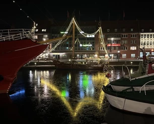 Illuminated ship in the Ratsdelft with light reflections on the water.