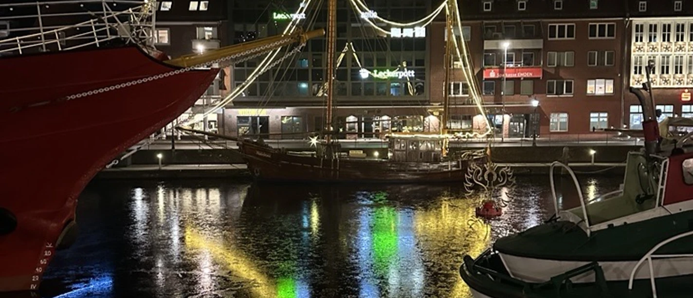 Maritimer Engelkemarkt .png Beleuchtetes Schiff im Ratsdelft mit Lichterspiegelungen auf dem Wasser.