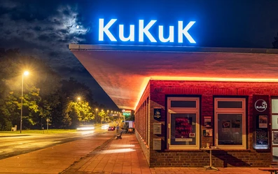 Deutsches Zollhaus (c) KuKuK e.V..jpg Leuchtende Fassade des Deutschen Zollhauses nachts, mit Neonlicht und beleuchtetem KuKuK-Logo.