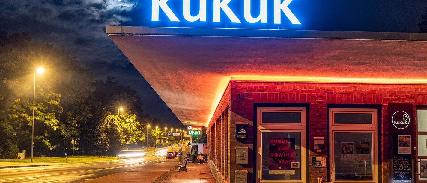 Deutsches Zollhaus (c) KuKuK e.V..jpg Leuchtende Fassade des Deutschen Zollhauses nachts, mit Neonlicht und beleuchtetem KuKuK-Logo.