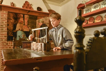 Kranichhaus Otterndorf Junge erkundet historische Mausefalle im Museum Kranichhaus Otterndorf.