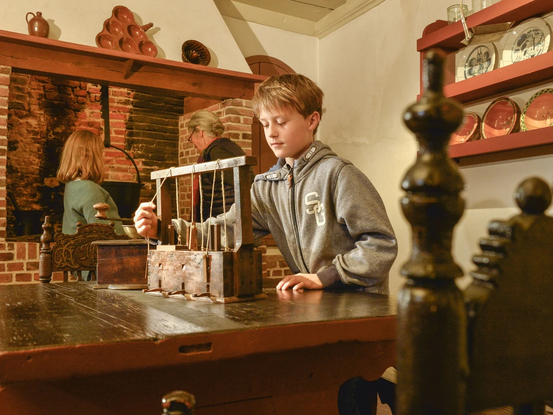 Kranichhaus Otterndorf Junge erkundet historische Mausefalle im Museum Kranichhaus Otterndorf.