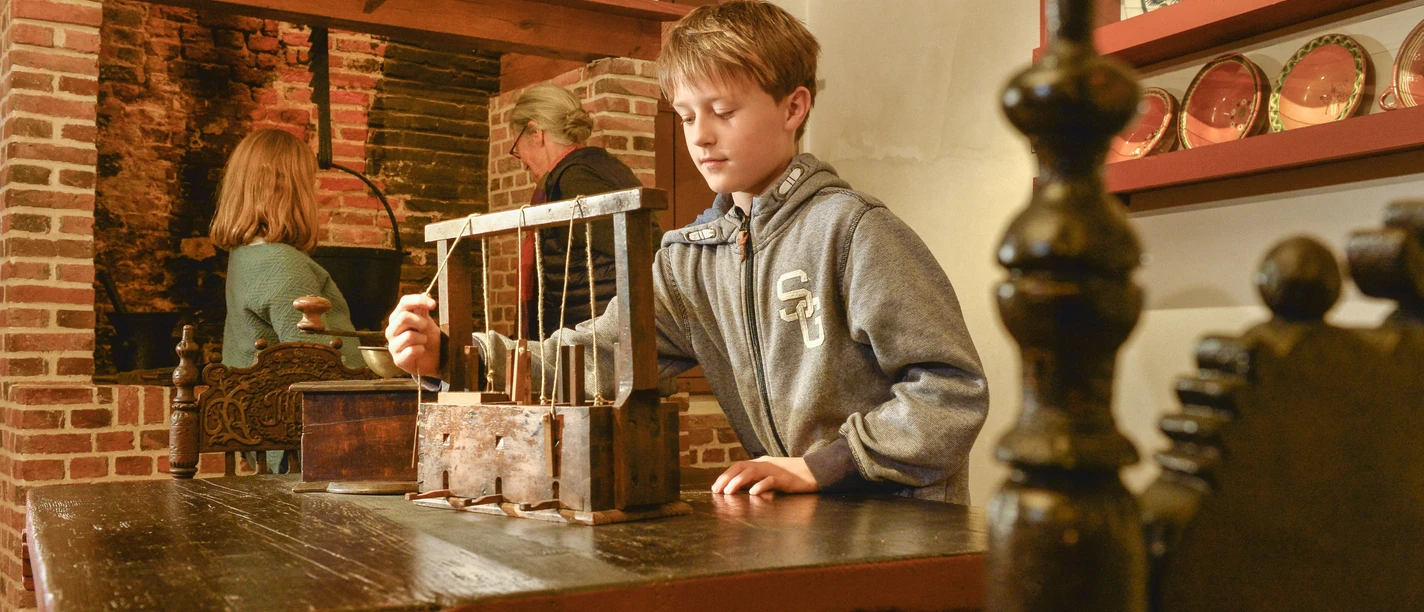 Kranichhaus Otterndorf Junge erkundet historische Mausefalle im Museum Kranichhaus Otterndorf.