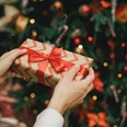 Young,Woman,Holding,Wrapped,Christmas,Present,With,A,Red,Ribbon, Young,Woman,Holding,Wrapped,Christmas,Present,With,A,Red,Ribbon,