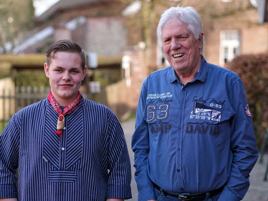 Enno Nico Werner 04.jpg Ein junger und ein älterer Mann stehen draußen und lächeln freundlich.