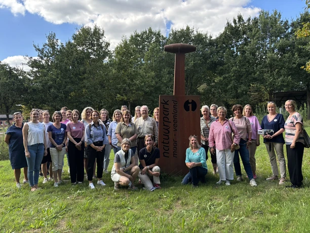 Die Meppener Grundschulen folgen der Einladung des Naturparks zur Lehrerfortbildung.JPEG Gruppe von Lehrkräften steht im Grünen vor dem Schild des Naturparks Moor-Veenland in Meppen.