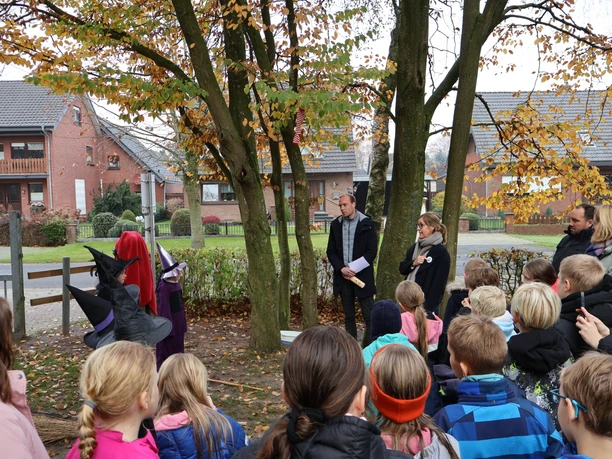 Wie alt ist MOORex eigentlich.JPG Kinder und Erwachsene lauschen im Park zwei verkleideten Hexen bei einer herbstlichen Schulaktion.