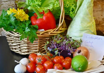 Wochenmarkt Frisches Marktgemüse mit Tomaten, Paprika, Kräutern und Salat in einem geflochtenen Korb.