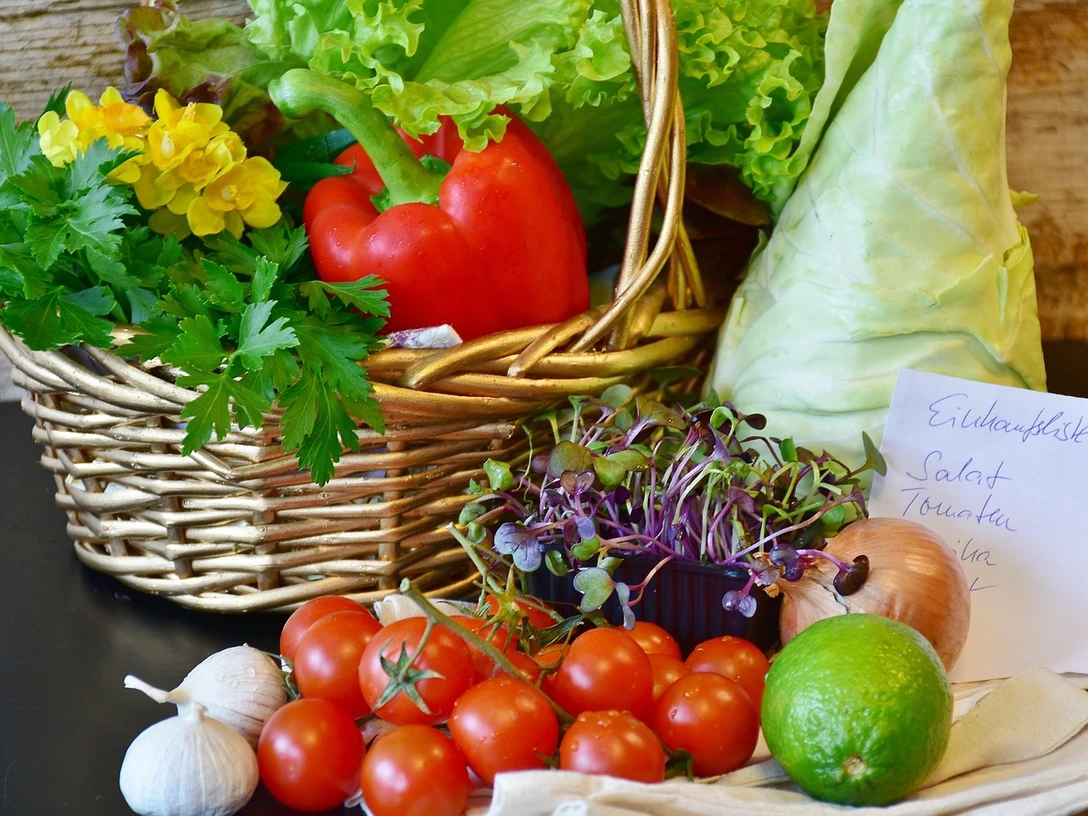 Wochenmarkt Frisches Marktgemüse mit Tomaten, Paprika, Kräutern und Salat in einem geflochtenen Korb.